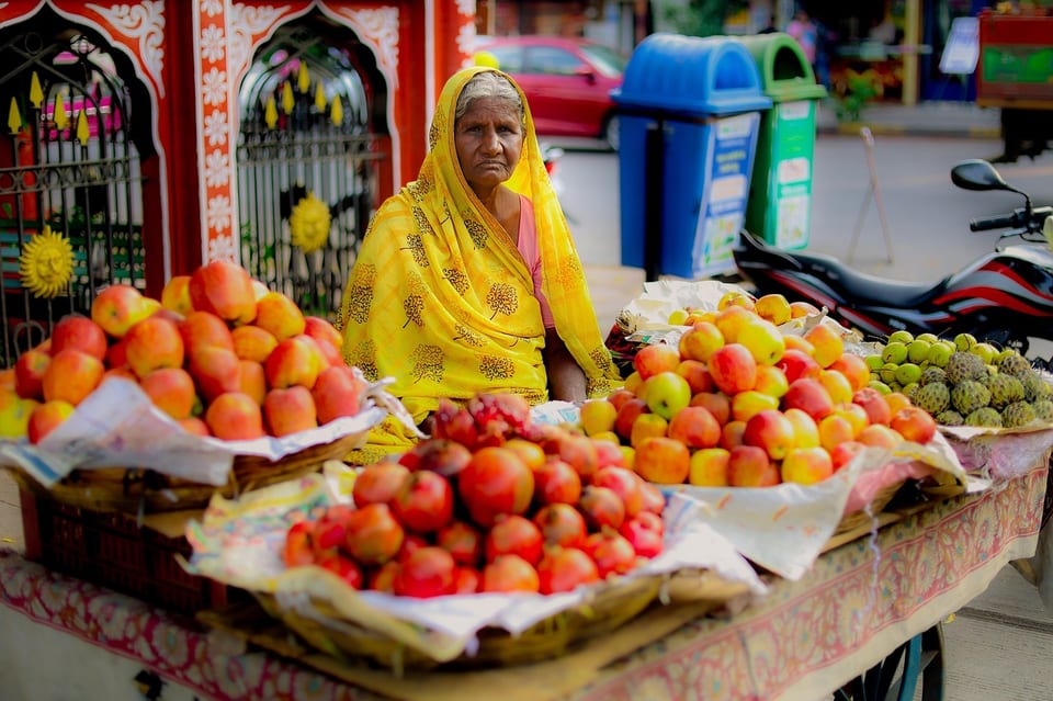 A street market stall piled with fruit and vegetables